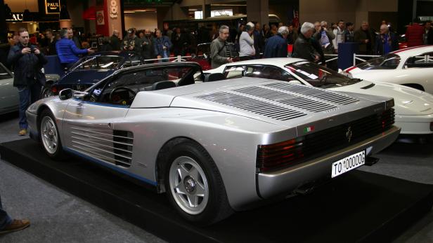 Ein silberner Ferrari Testarossa Spider auf einer Automobilausstellung.