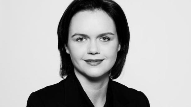 Schwarz-Weiß-Porträt einer Frau mit dunklen Haaren und dunklem Blazer.