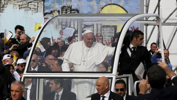 Papst Franziskus fährt in einem Papamobil durch eine Menschenmenge.