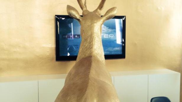 Eine goldene Hirschstatue steht in einem Büro.