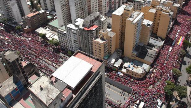 epa03612982 A handout picture provided by the Presidency of Venezuela shows thousands of people taking part in the funeral parade in tribute to late Venezuelan President Hugo Chavez in Caracas, Venezuela, 06 March 2013. Chavez died on 05 March of complications related to cancer in a military hospital in Caracas, Venezuela. The burial will be on 08 March. EPA/PRESIDENCY OF VENEZUELA HANDOUT EDITORIAL USE ONLY/NO SALES