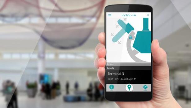 Eine Hand hält ein Smartphone mit einer App zur Navigation im Terminal 3 des Flughafens Kopenhagen.