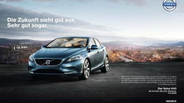 Ein blauer Volvo V40 vor einer Stadtlandschaft bei Dämmerung.