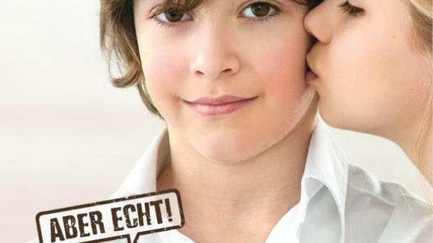 Ein Mädchen gibt einem Jungen einen Kuss auf die Wange; Werbung für Ströck Cranberry-Spitz.