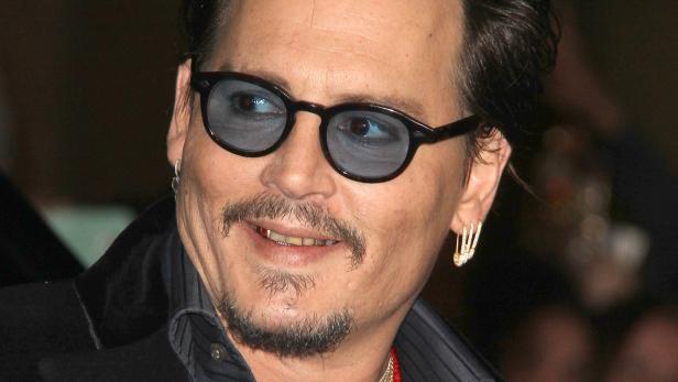 Johnny Depp zeigt seine Zahnverfärbungen.