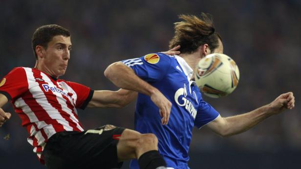 Zwei Fußballspieler kämpfen um den Ball während eines Spiels.
