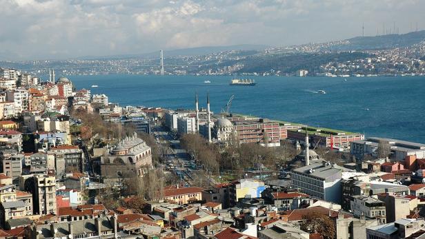 Blick über Istanbul mit Moscheen, Wohnhäusern und dem Bosporus im Hintergrund.