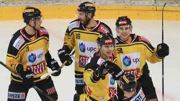 Eishockeyspieler der Vienna Capitals in gelb-schwarzen Trikots auf dem Eis.
