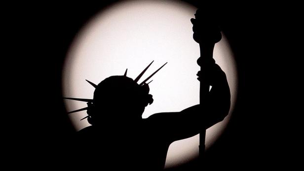 Die Silhouette der Freiheitsstatue vor einem hellen Hintergrund.