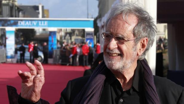 Ein lächelnder Mann mit Brille auf dem roten Teppich des Filmfestivals von Deauville.