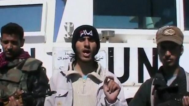 A member of the Al Yarmouk Martyr brigade makes a statement in front of a white vehicle with &#039;UN&#039; written on it at what said to be Jamla, Syria near Golan Heights on March 6, 2013 in this still image taken from video posted on social media website. Syrian rebels have seized a convoy of U.N. peacekeepers near the Golan Heights and say they will hold them captive until President Bashar al-Assad&#039;s forces pull back from a rebel-held village which has seen heavy recent fighting. The capture was announced in rebel videos posted on the Internet and confirmed on Wednesday by the United Nations in New York, which said about 20 peacekeepers had been detained. REUTERS/Social Media Website via Reuters TV (SYRIA - Tags: CIVIL UNREST POLITICS) ATTENTION EDITORS - THIS PICTURE WAS PROVIDED BY A THIRD PARTY. REUTERS IS UNABLE TO INDEPENDENTLY VERIFY THE AUTHENTICITY, CONTENT, LOCATION OR DATE OF THIS IMAGE. FOR EDITORIAL USE ONLY. NOT FOR SALE FOR MARKETING OR ADVERTISING CAMPAIGNS. NO SALES. NO ARCHIVES. THIS PICTURE IS DISTRIBUTED EXACTLY AS RECEIVED BY REUTERS, AS A SERVICE TO CLIENTS