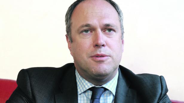 Porträt eines Mannes in Anzug und Krawatte.