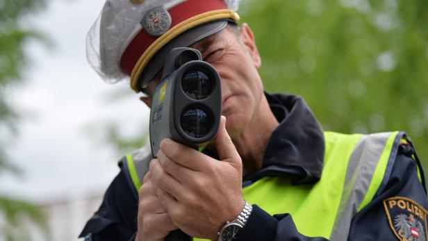 Ein österreichischer Polizist misst die Geschwindigkeit mit einem Lasergerät.