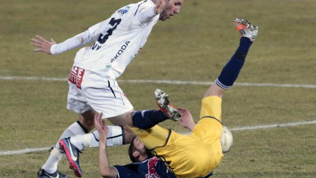 Ein Fußballspieler grätscht einen anderen während eines Fußballspiels ab.