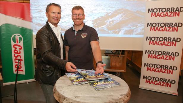 Zwei Männer präsentieren das „Motorrad Magazin“ vor einer Landschaftsprojektion.