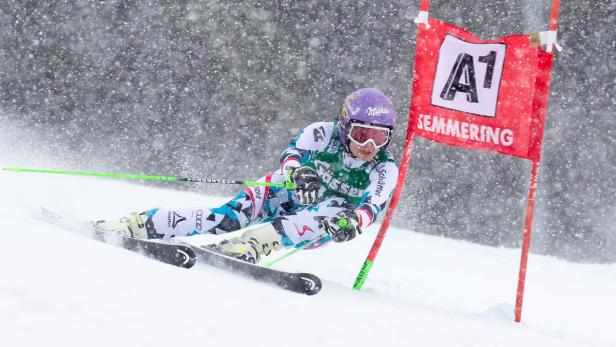 Eine Skirennläuferin fährt bei starkem Schneefall einen Slalomkurs in Semmering hinunter.