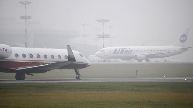 Zwei Flugzeuge stehen im Nebel auf einem Rollfeld.