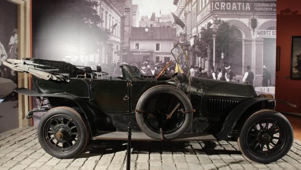 Ein Oldtimer steht vor einer historischen Stadtkulisse.