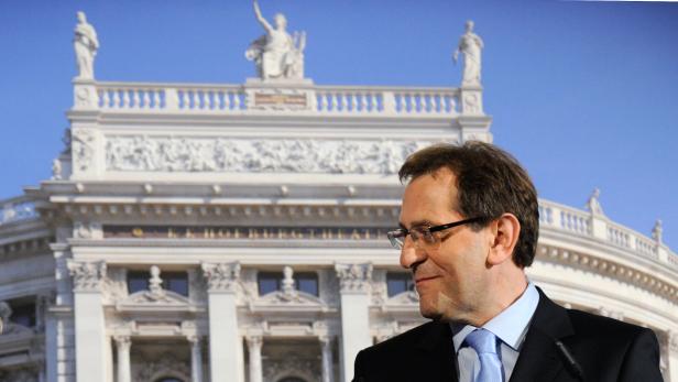 Ein Mann mit Brille steht vor dem Burgtheater in Wien.