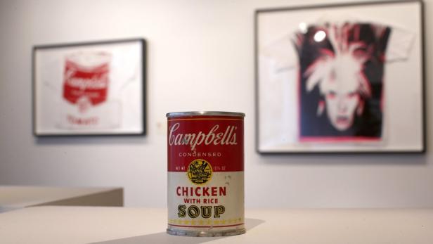 Artist Andy Warhol&#039;s &#039;Campbell&#039;s Chicken with Rice Soup&#039; (C, front), an aluminium can with paper decal, ca. 1964 (estimate is $50,000 to 70,000), on the wall &#039;Campbell&#039;s Tomato Soup&#039; (L), a screen print on t-shirt, ca 1981 (estimate is $12,000 to 15,000) and &#039;Self-Portrait with Fright Wig&#039; (C), a screen print on t-shirt, ca. 1986 (estimate is $15,000-20,000) are seen on display at Christie&#039;s in New York City February 22, 2013. One hundred and twenty-five works by the artist are the subject of an exhibition and upcoming online auction sale announced by Christie&#039;s in partnership with The Andy Warhol Foundation for the Visual Arts, to take place from February 26 to March 5, 2013. REUTERS/Mike Segar (UNITED STATES - Tags: ENTERTAINMENT SOCIETY)