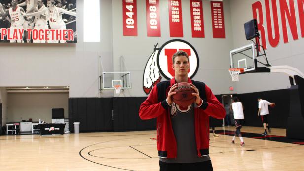 Ein Basketballspieler der Utah Utes posiert mit einem Wilson-Basketball in einer Turnhalle.