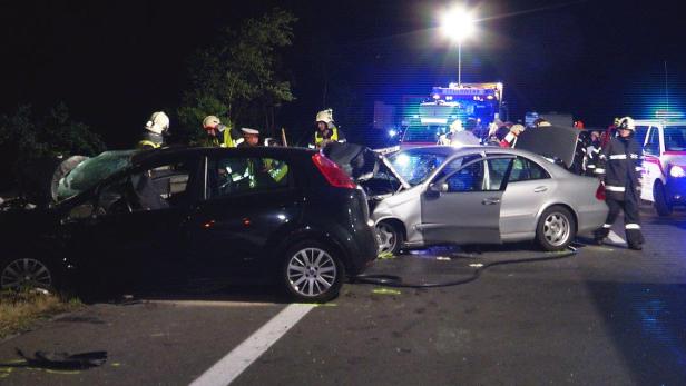 Nach einem Autounfall arbeiten Feuerwehrleute an der Unfallstelle.