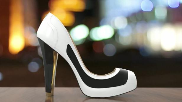 Ein weißer High Heel mit schwarzen Akzenten steht auf einem Tisch.