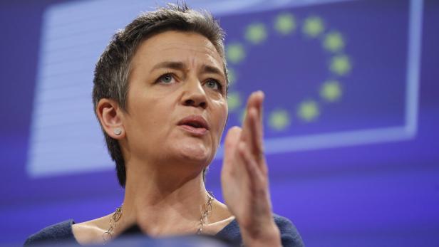 Margrethe Vestager spricht vor dem Hintergrund der EU-Flagge.
