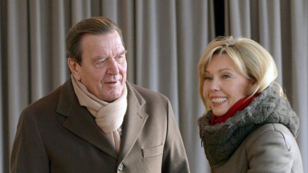 Gerhard Schröder und eine Frau stehen nebeneinander und lächeln.