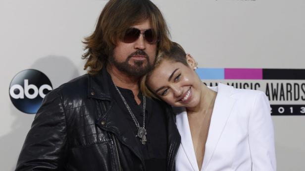 Billy Ray Cyrus und Miley Cyrus posieren zusammen auf dem roten Teppich.