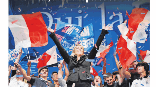 Marine Le Pen feiert mit Anhängern und französischen Flaggen bei einer Wahlveranstaltung.