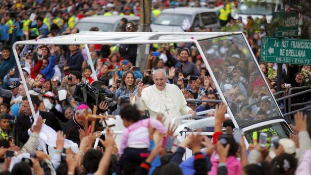 Papst Franziskus winkt der jubelnden Menge aus seinem Papamobil zu.