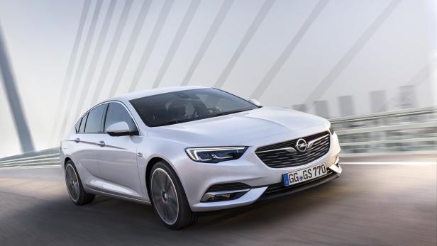 Ein weißer Opel Insignia fährt auf einer Brücke.