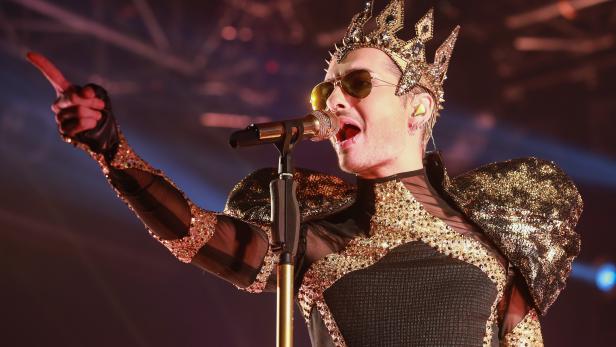 Bill Kaulitz von Tokio Hotel tritt in einem goldenen Bühnenoutfit auf.