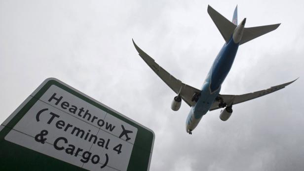 Ein Flugzeug überfliegt ein Schild zum Terminal 4 des Flughafens Heathrow.