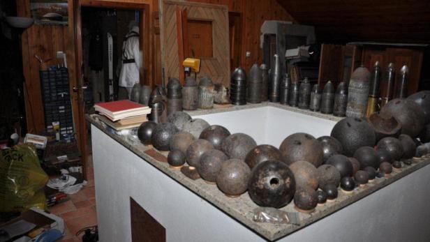 Eine Sammlung von alten Kanonenkugeln und Munition in einem Raum.
