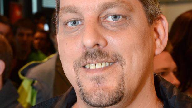 Porträt eines Mannes mit Bart und blauen Augen.