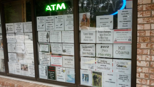 Ein Schaufenster ist mit politisch aufgeladenen und teils beleidigenden Zetteln beklebt.