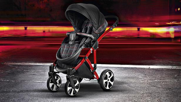 Ein Kinderwagen mit rotem Rahmen und schwarzem Sitz steht auf einer Straße.