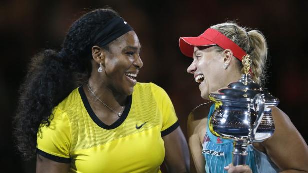 Serena Williams und Angelique Kerber lachen zusammen mit der Trophäe in der Hand.