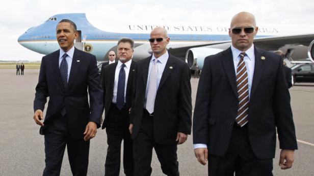 Barack Obama geht mit Sicherheitsbeamten vor der Air Force One entlang.