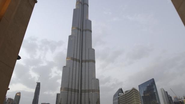 Der Burj Khalifa überragt eine Menschenmenge am Wasser in Dubai.