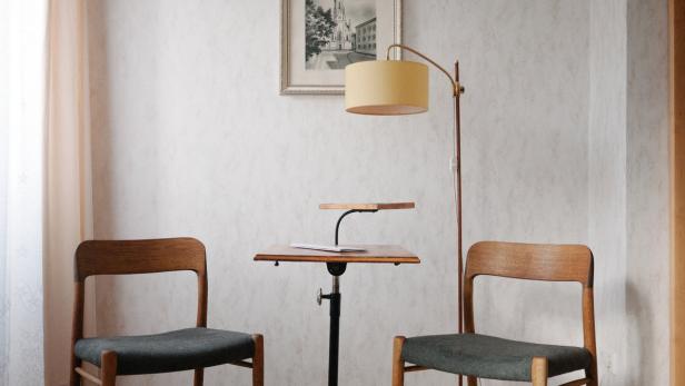 Zwei Stühle und ein Tisch mit Lampe in einem hellen Raum.