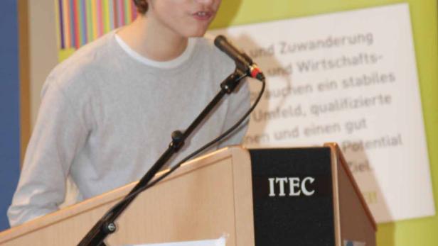 Ein junger Mann spricht an einem Rednerpult mit der Aufschrift „ITEC“.