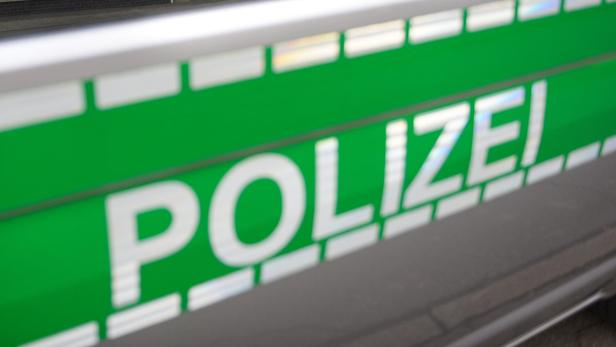 Detailansicht der Aufschrift „Polizei“ auf einem Streifenwagen.