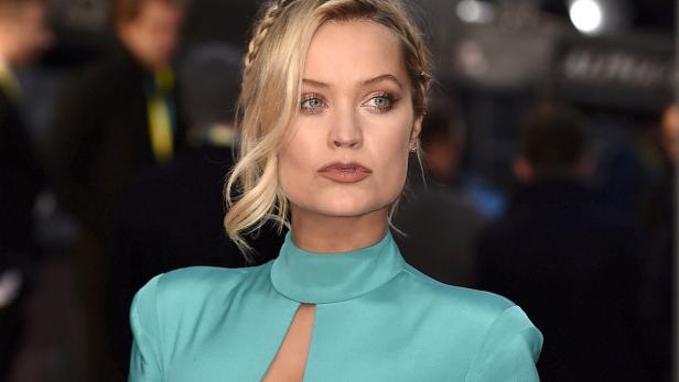 Laura Haddock mit blonden Zöpfen und einem türkisfarbenen Kleid.