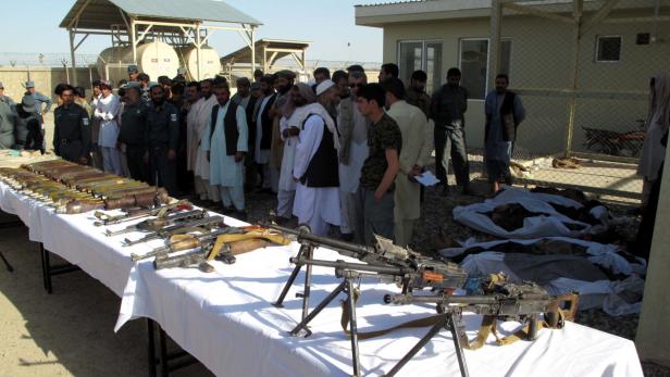 Afghanische Sicherheitskräfte präsentieren die Waffen der bereits getöteten Taliban-Kämpfer.