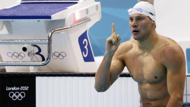 Ein Schwimmer steht am Beckenrand und feiert seinen Sieg bei den Olympischen Spielen 2012 in London.