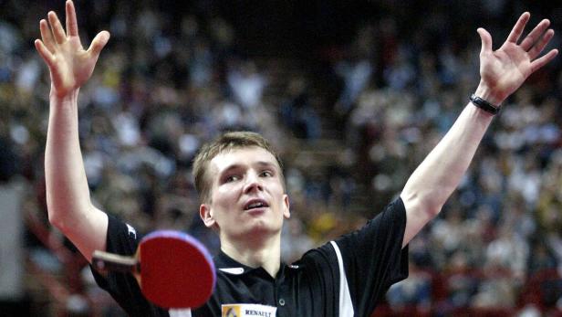 Ein Tischtennisspieler jubelt mit erhobenen Armen vor einer Zuschauermenge.