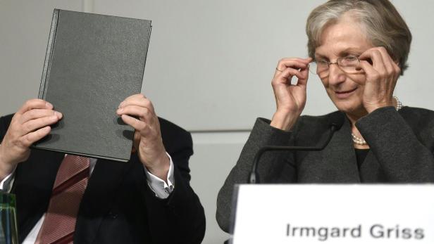 Irmgard Griss bei einer Pressekonferenz, während eine Person ihr Gesicht mit einem Buch verdeckt.